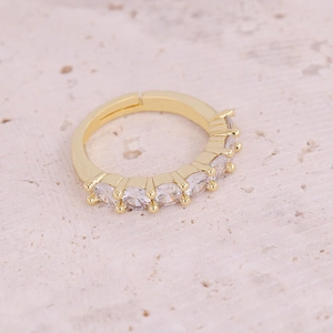 Detail eines verstellbaren Goldrings mit einer Reihe von sechs funkelnden Zirkonia