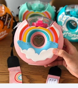 Detailed view of donut shaped kids water bottle with rainbow pattern and pink strap