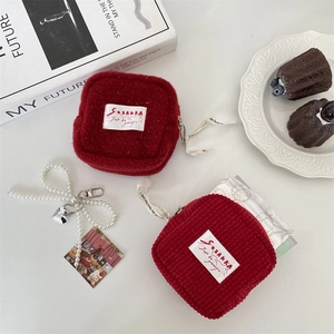 Detail of red corduroy and plush sanitary pouch with zipper and woven label