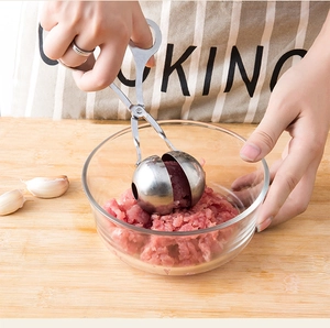 Close-up of stainless steel meatball maker scooping fresh meat in a kitchen