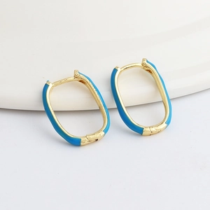 Detail of gold oval hoop earrings featuring vibrant blue enamel and a hinged closure