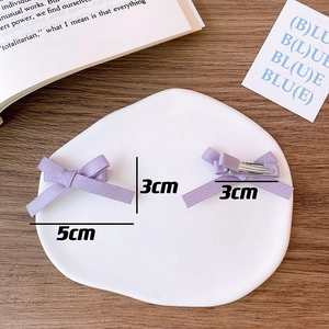 Detail of a 5cm lavender satin bow hair clip with silver metal duckbill clip for women