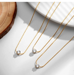 Close-up of three 18K gold plated snake bone necklaces with sparkling zircon pendants