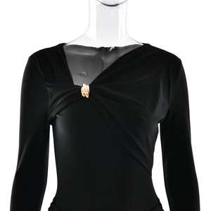 Detail of elegant V-neckline featuring a gold metal buckle on a slim black dress