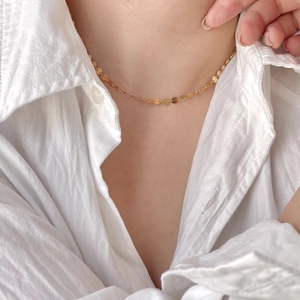 Minimalist 925 sterling silver gold-plated choker with small round discs on a model