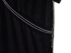 Close-up of black velvet dress showing premium texture and shiny piped edge seams