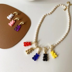 Dettaglio dei ciondoli a forma di orsetto colorato su una collana di perle