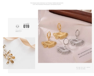 Detailed close-up of ginkgo leaf earrings in gold and silver finish with metallic texture