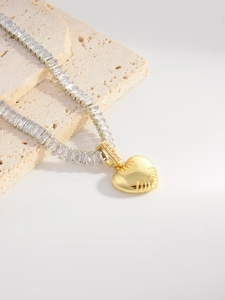 Detailed macro view of heart pendant necklace with radiant texture and rectangle zircons