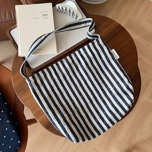 Detailed close-up of blue and white striped canvas tote bag with Simple Wish woven label
