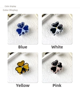 Macro detail of four mini clover acetate hair claws with sparkling rhinestone centers