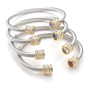 Detail of four cable twist bangles featuring colorful gemstones and gold-plated end caps