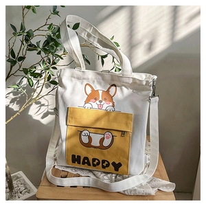 Close-up of white canvas tote with yellow Corgi pocket on a wooden stool