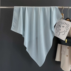 Detail showing the light blue silk scarf draped over a metal rod with soft texture