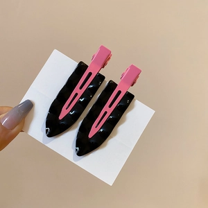 Detailed close-up of wave-textured black and pink hair clips on a white display card