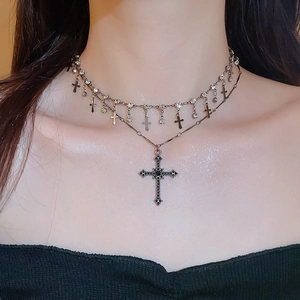 Close-up of a double-layer vintage gothic necklace with black cross pendant and stones