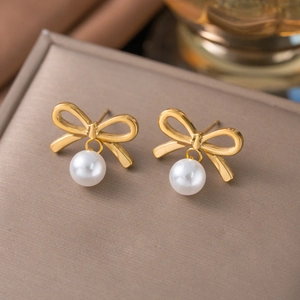 18k gold plated stainless steel bow earrings with hanging white pearls on jewelry box