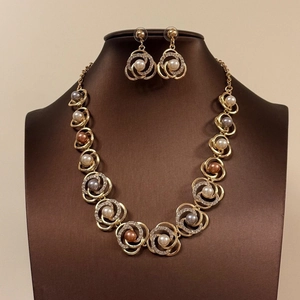 Elegante conjunto de collar y pendientes de flores y perlas en soporte de exhibición
