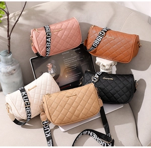 Close-up of five quilted baguette bags in various colors with wide branded shoulder straps