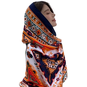 Ethnic print sun protection shawl for beach travel worn by a model in a side view profile