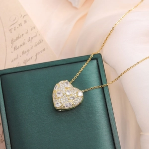 Gold-plated heart pendant necklace with shimmering cubic zirconia on elegant jewelry box