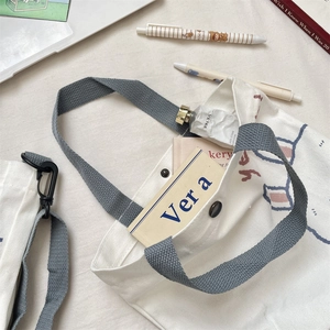 Close-up of durable canvas tote with blue handles and organized inner pocket storage