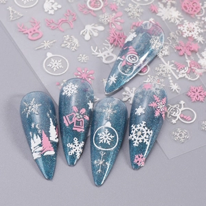 Close-up of 5D embossed Christmas nail stickers with white snowflakes and pink reindeer