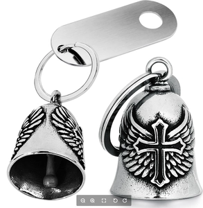 Detailed view of silver motorcycle guardian bell with wings and cross relief carvings
