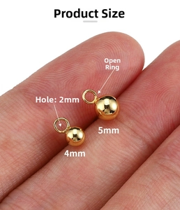 Macro view of 4mm and 5mm 14k gold-plated ball studs with open rings for DIY jewelry