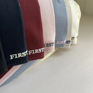 Close-up of FIRST embroidery on cotton baseball cap brims in multiple colors