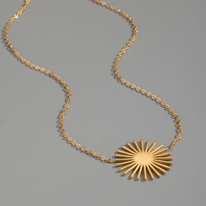 Vue détaillée du pendentif soleil doré avec rayons sur une fine chaîne élégante