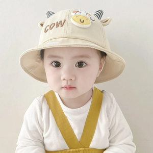 Close-up of baby beige fisherman hat with cute cow horns and soft cotton texture