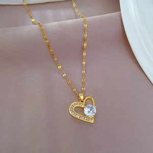 Close-up of a gold-plated heart pendant with a large clear zircon and O-chain details
