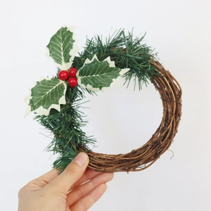 Détail d'une couronne de bougie de Noël avec baies rouges et aiguilles de pin