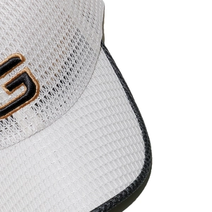Close-up of mesh fabric texture and black G letter embroidery on white baseball cap