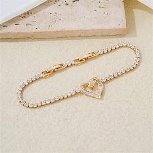 Detail of gold heart tennis bracelet with adjustable slider and sparkling zircons