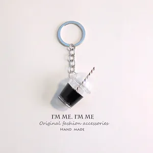 Close-up of a miniature iced drink keychain with coffee and a striped straw detail