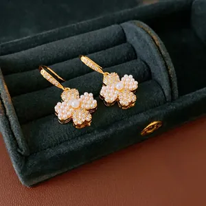 Gold plated four-leaf clover flower drop earrings with white pearls and sparkling zircons