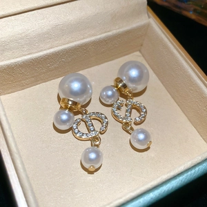 Detail of gold-plated CD pearl earrings with sparkling zircons in a jewelry box