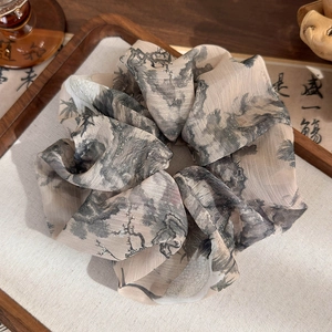 Detail of Chinese ink calligraphy fabric scrunchie on a decorative wooden tray
