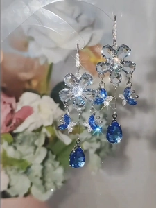 Detail of long butterfly tassel earrings with blue crystals and waterdrop pendants