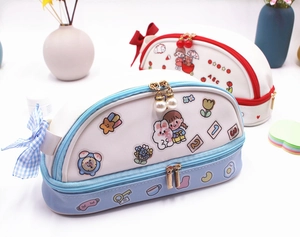 Détail de la trousse à double couche avec motifs de dessins animés et pendentif perle