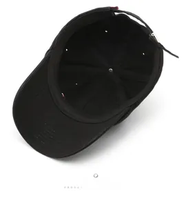 Detailed interior of black cotton baseball cap showing 6-panel stitching and adjustable strap