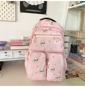 Pink nylon school backpack detail with cute white bear print and multiple zipper pockets