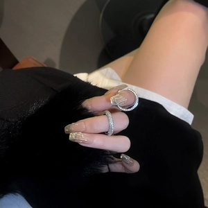 Close-up of minimalist silver zircon rings worn as a set with stylish nail art