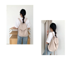 Dettaglio dello zaino in nylon beige che mostra la chiusura a coulisse e gli spallacci regolabili