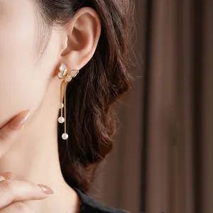 Elegant gold butterfly tassel earrings with white pearls and iridescent mother of pearl