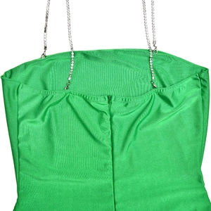 Macro detail of sexy green satin backless dress with silver rhinestone chain straps