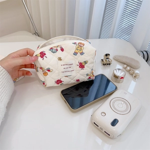 Close-up of quilted cotton makeup bag with cute cartoon prints and soft texture