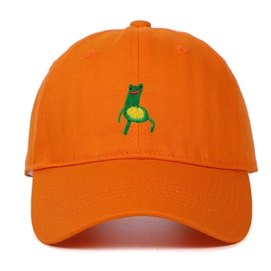 Detail of green frog embroidery on vibrant orange cotton twill baseball cap fabric